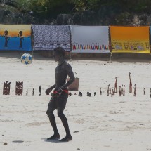 Youngster playing soccer on the beach